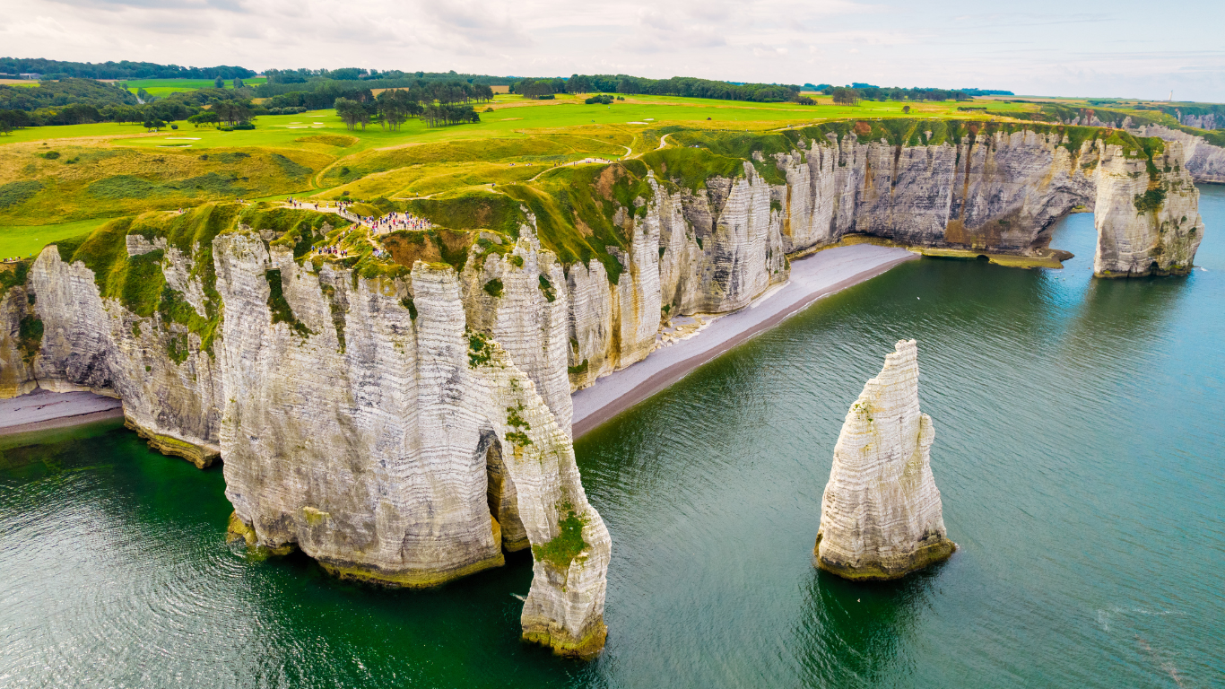 Ariel view of the Étretat Cliffs with needle like rocks shooting up out of the water