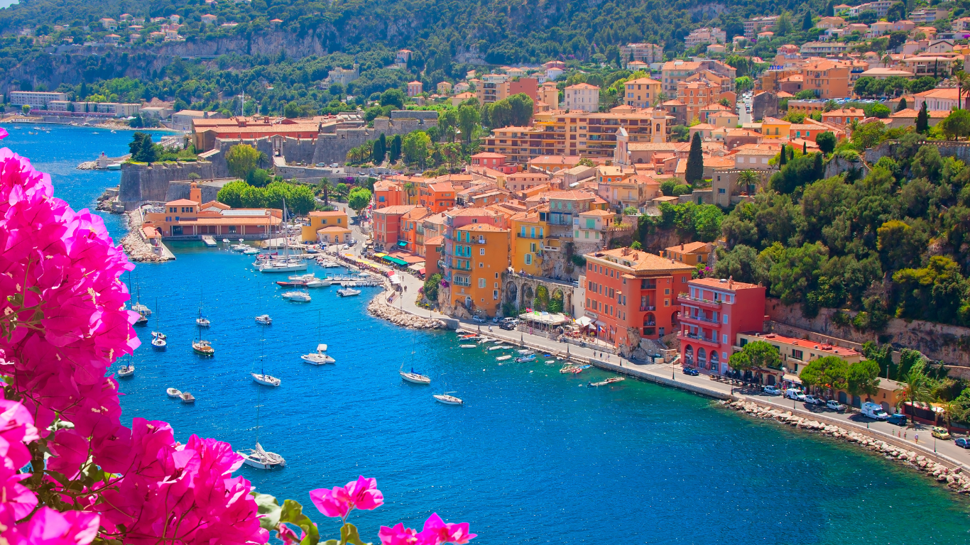 cliff view near bright flowers looking across the bay to Côte d’Azur with boats anchored on a nice summer day