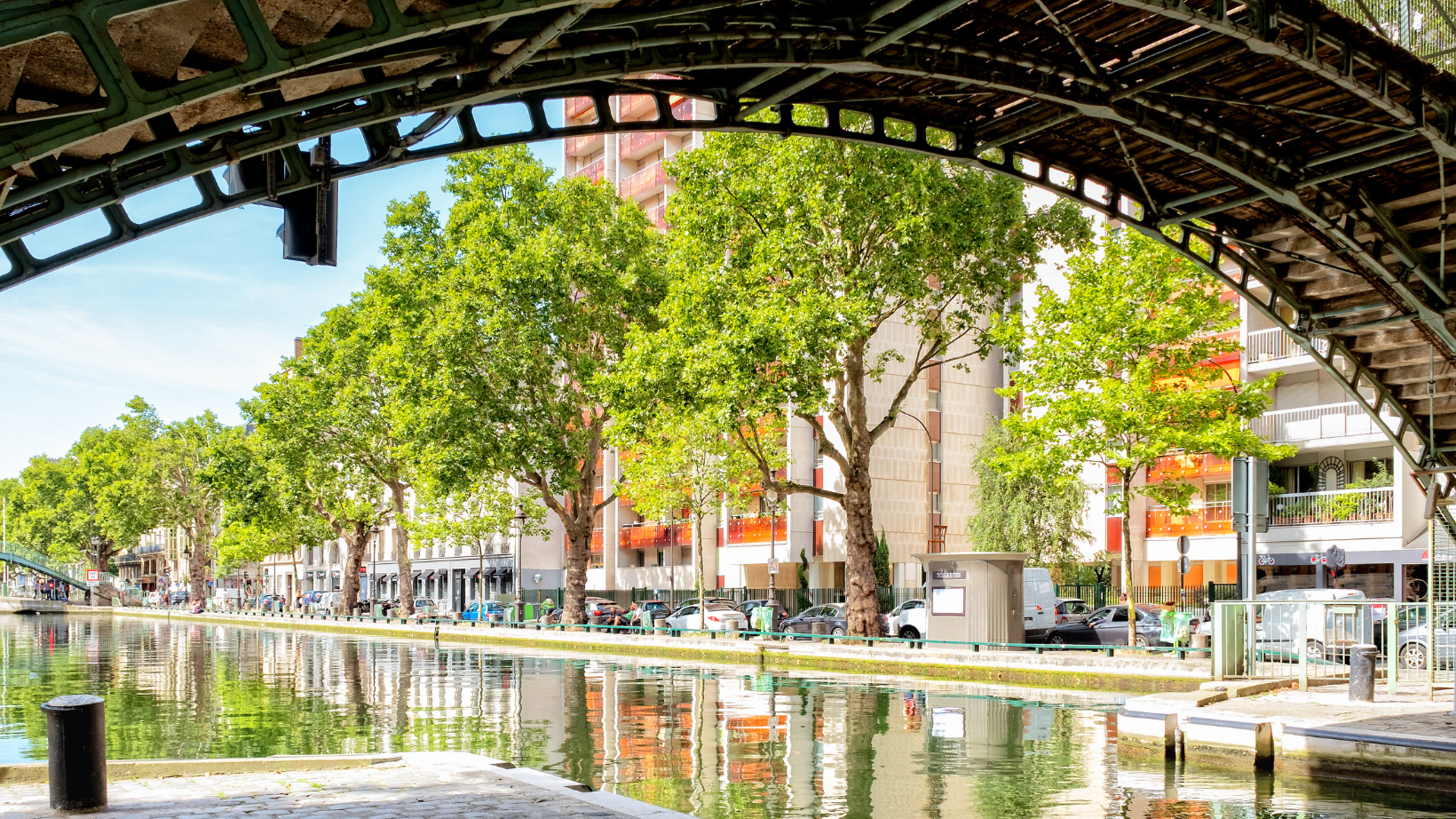 Canal Saint-Martin in paris in the daytime surrounded by trees and people walking