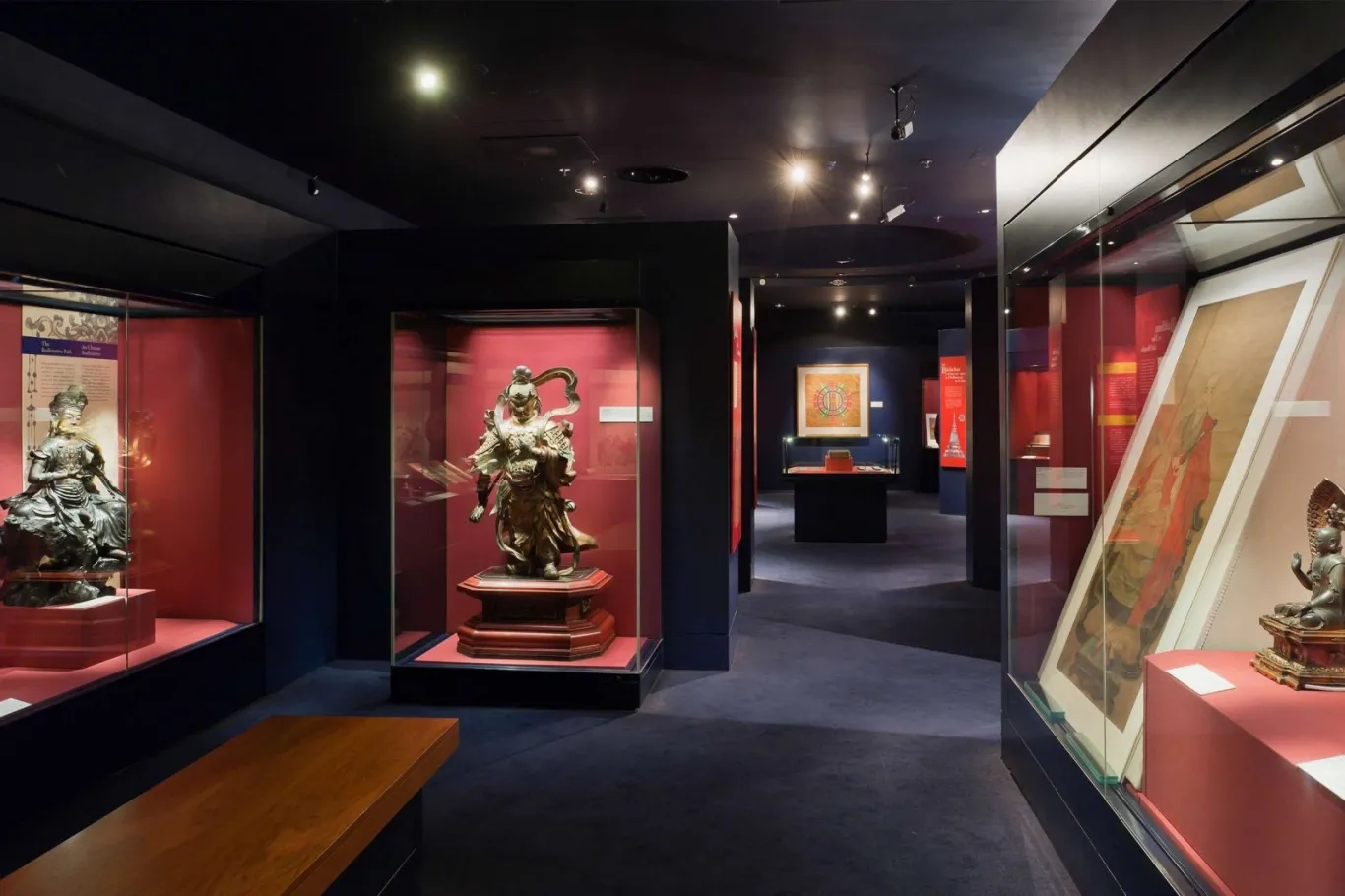 museum pieces in cased in glass with lights on them in a room at Chester Beatty Library 