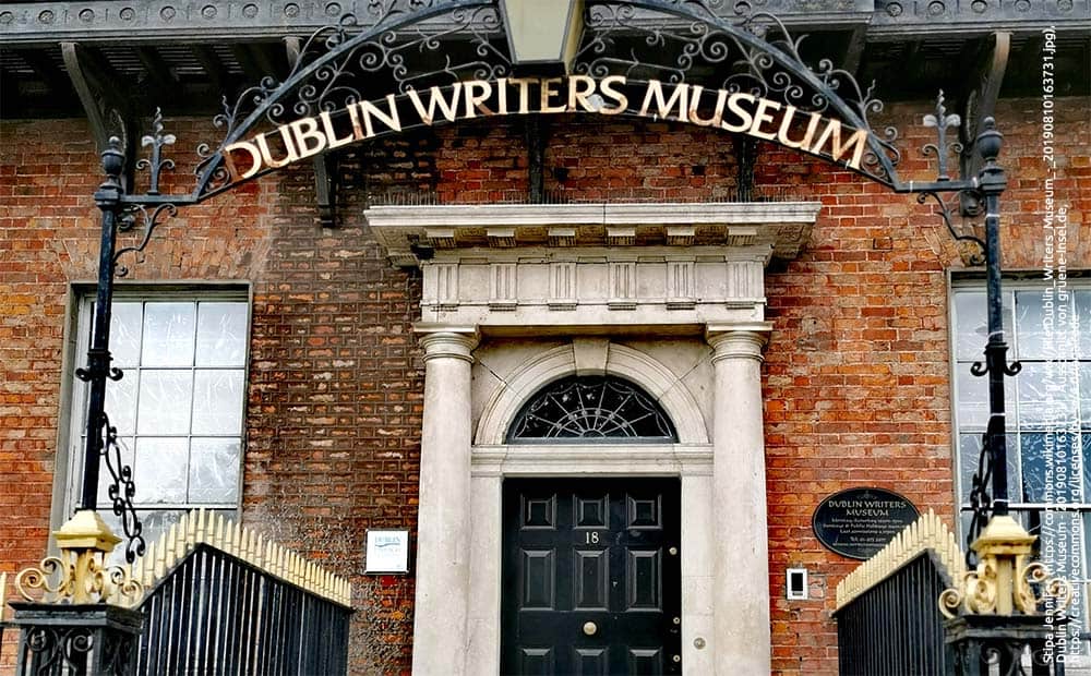 brick building and stairs leading up to a black door with number 18 on it with a walkway arch that says Dublin's Writers Museum