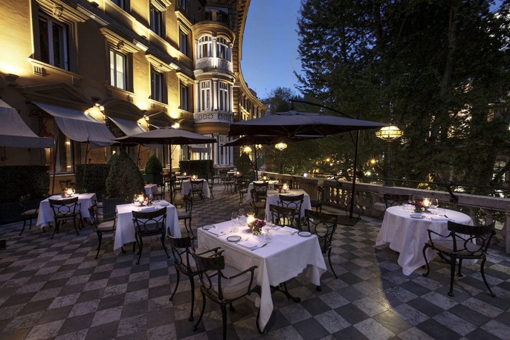 Hotel Majestic Roma Terrace at night with dining tables