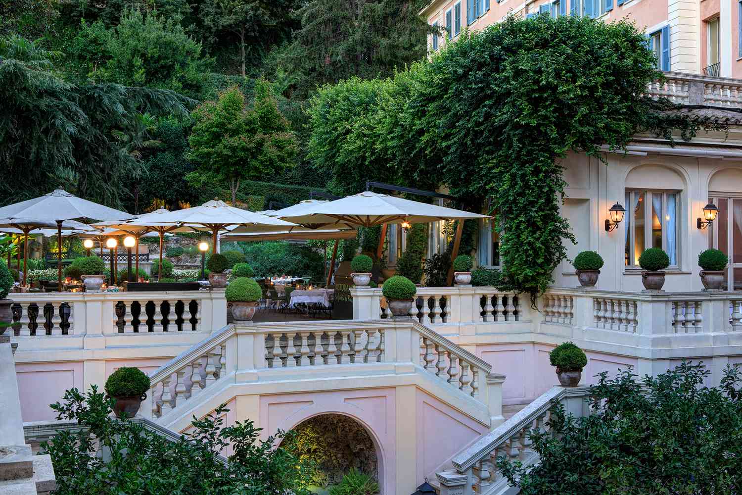 Hotel de Russie patio and stairs surrounded by lush green plants and trees