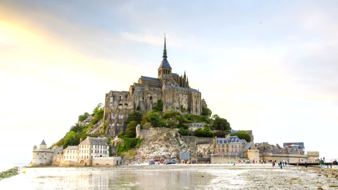 old Castle like building, Mont Saint-Michel Abbey in France with tourist viewing it on a cloudy day