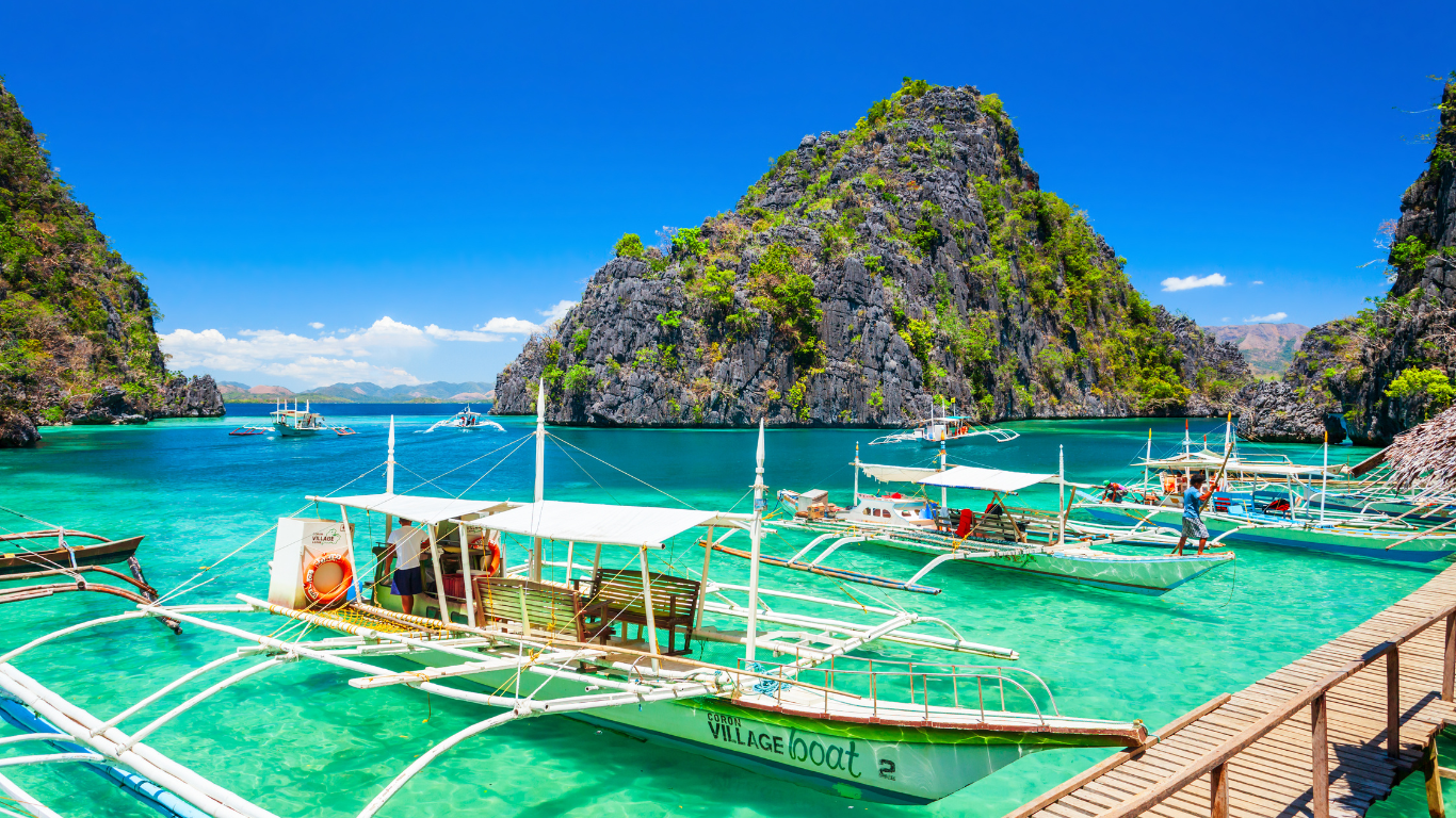 Palawan is a backpackers dream with crystal clear waters, and boats docking in a bay surrounded by mountains. 