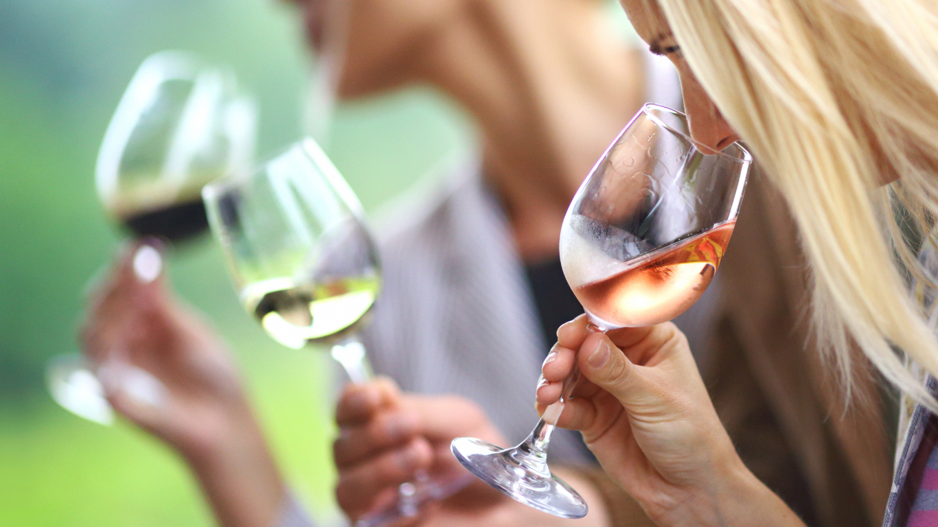 people sampling different types of wine at a wine tasting, smelling and really enjoying themselves 