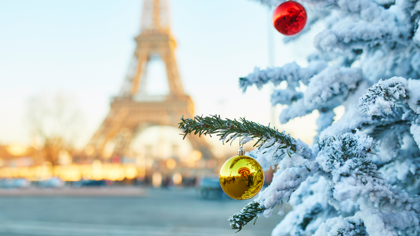 view of the Eiffel tower in the distance with Christmas tree with snow and ornaments showing how beautiful Paris is in the winter time 