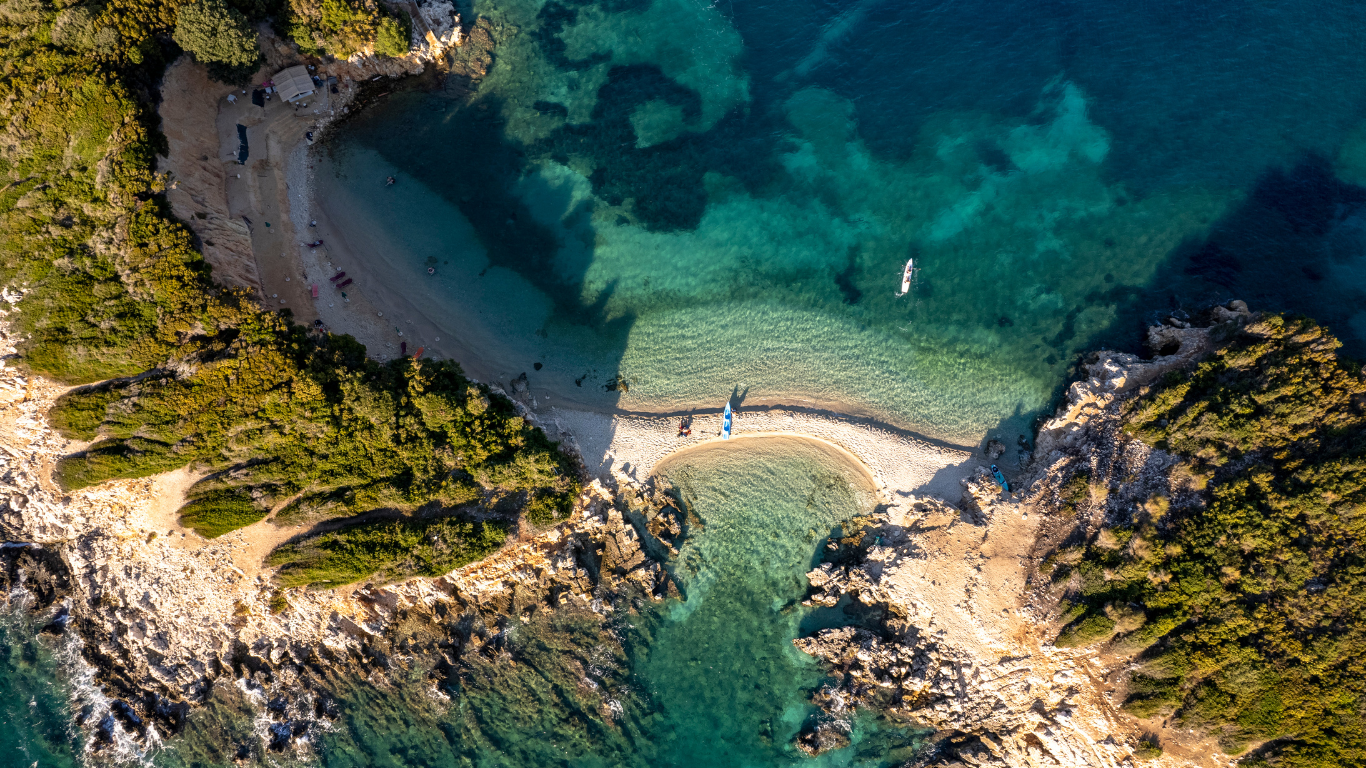 aerial view of a remote beach along the shore line in Riviera Nayarit Mexico that has a beach and the ocean on both side and a mountain splitting the water