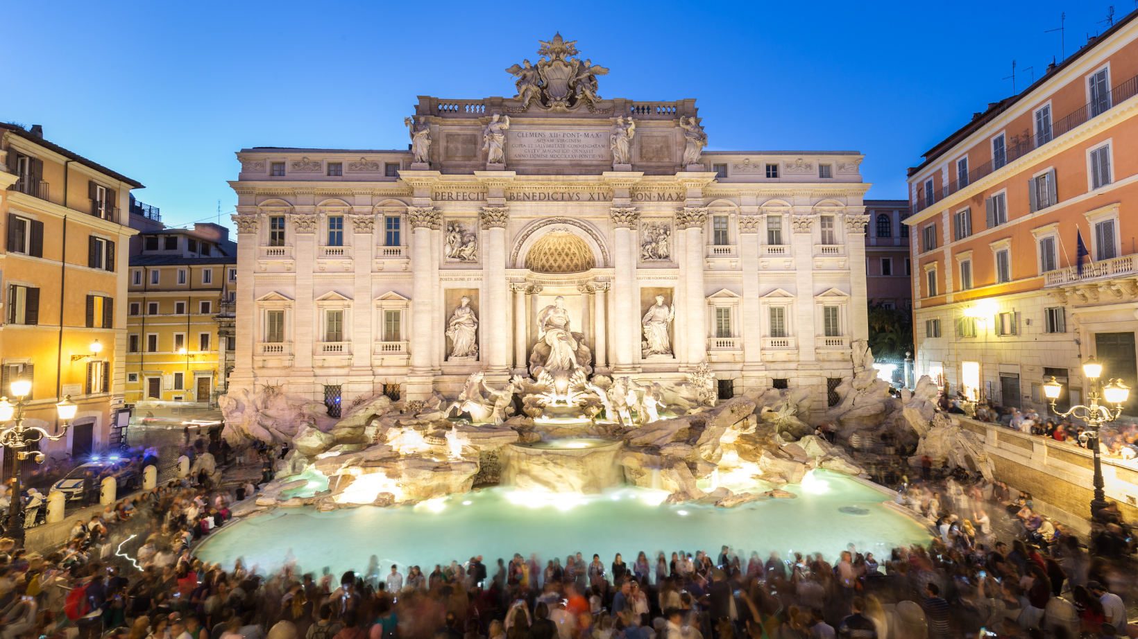 people surrounding Trevi fountain in Rome at night