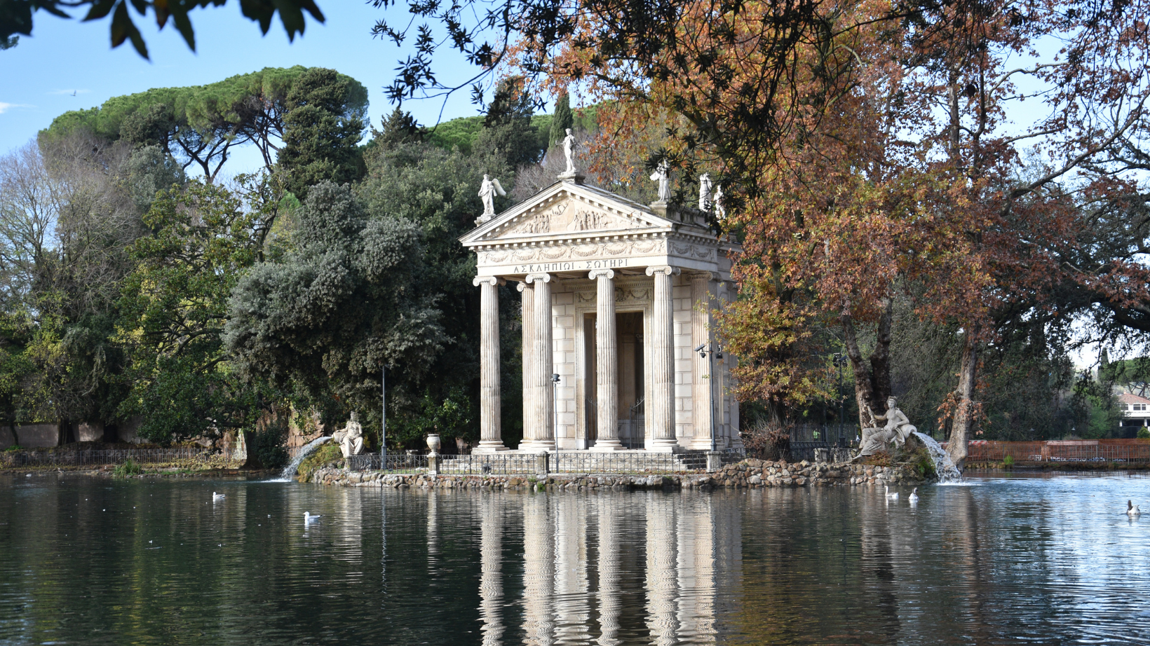 view of the lake with the monument in the background at Villa Borghese Gardens in Rome