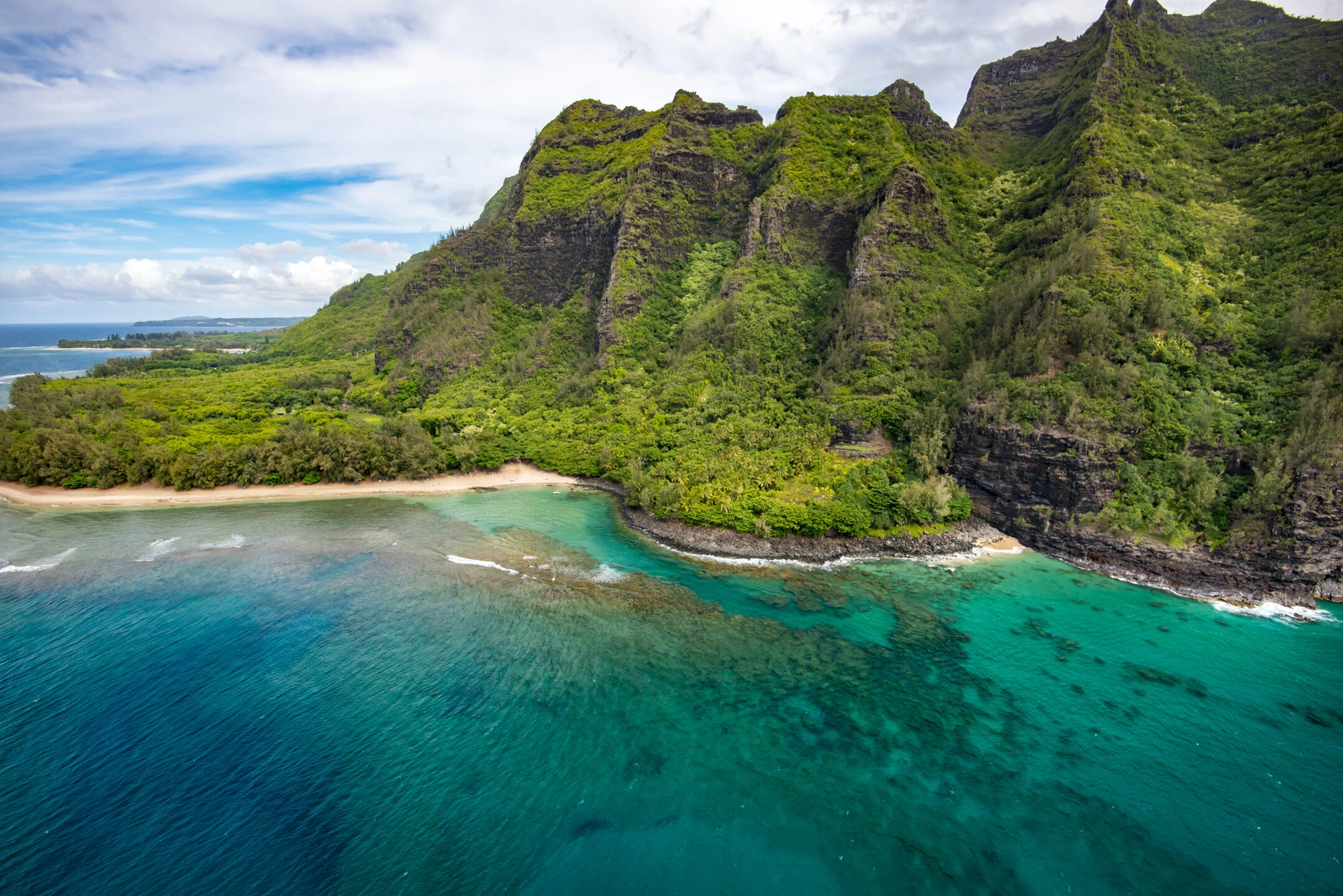 Rugged Ariel view of Kauai, Hawaii's North Shore with trees maintains and clear blue waters