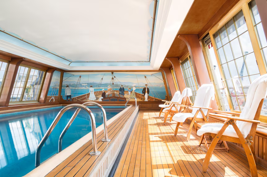 Le Bristol Paris hotel indoor swimming pool with wooden flooring and chairs