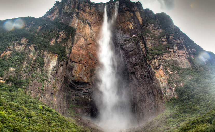 giant waterfall flowing off the tall mountain and mist flying in the air at Angel Falls, Venezuela