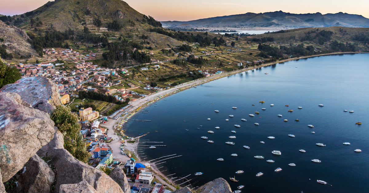 Copacabana, Bolivia- View of Lake Titicaca from the top of a cliff over looking the beach with lots of boats anchored 