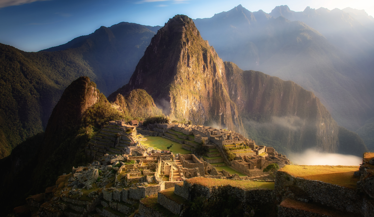 The sun rising and burning off the fog at Machu Picchu in Peru