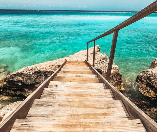 stairs going down into the clear ocean water in Aruba at Mangel Halto Beach