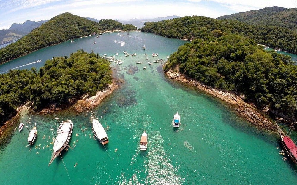  boats anchored by beautiful island with clean clear waters at Parque Estadual da Ilha Grande (Ilha Grande State Park)