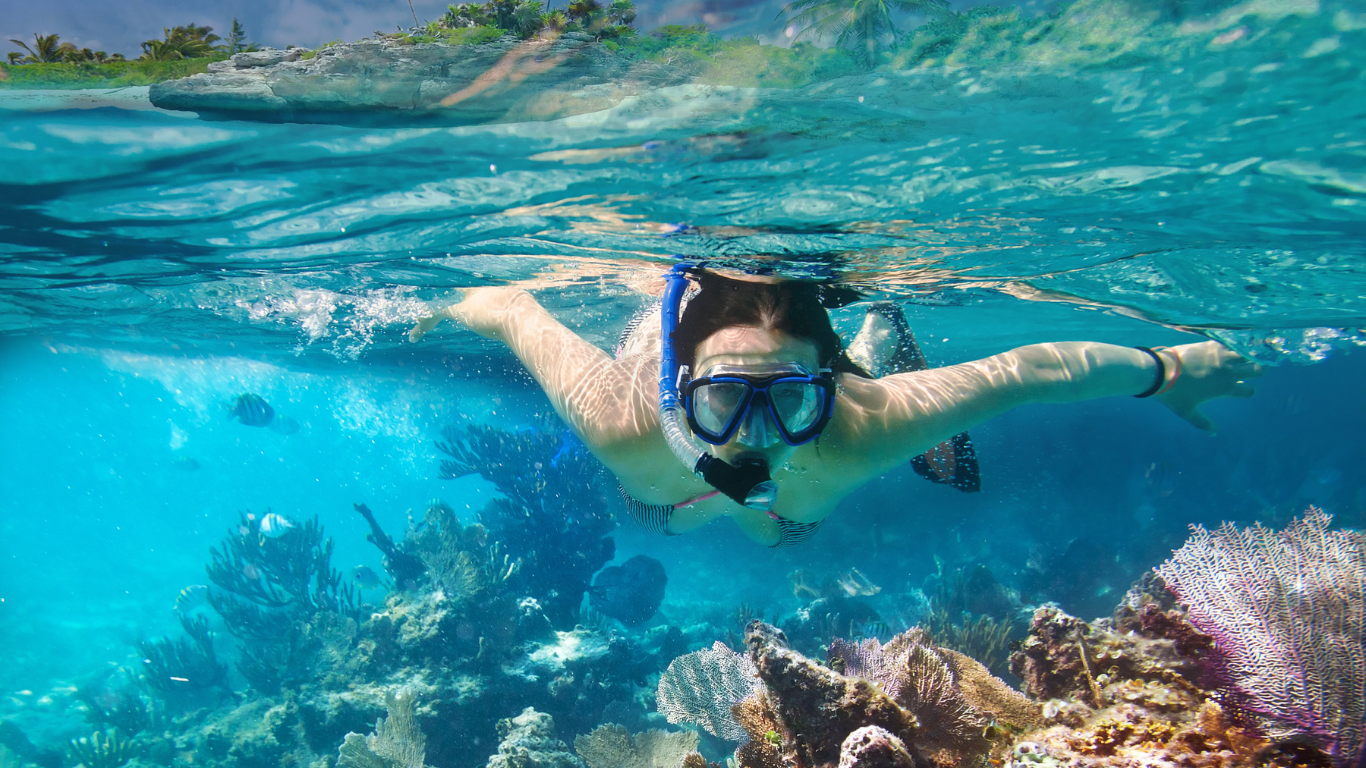 man taking a selfie underwater while snorkeling in Snorkel in Olowalu Maui, Hawaii with clear waters surrounded by coral reefs