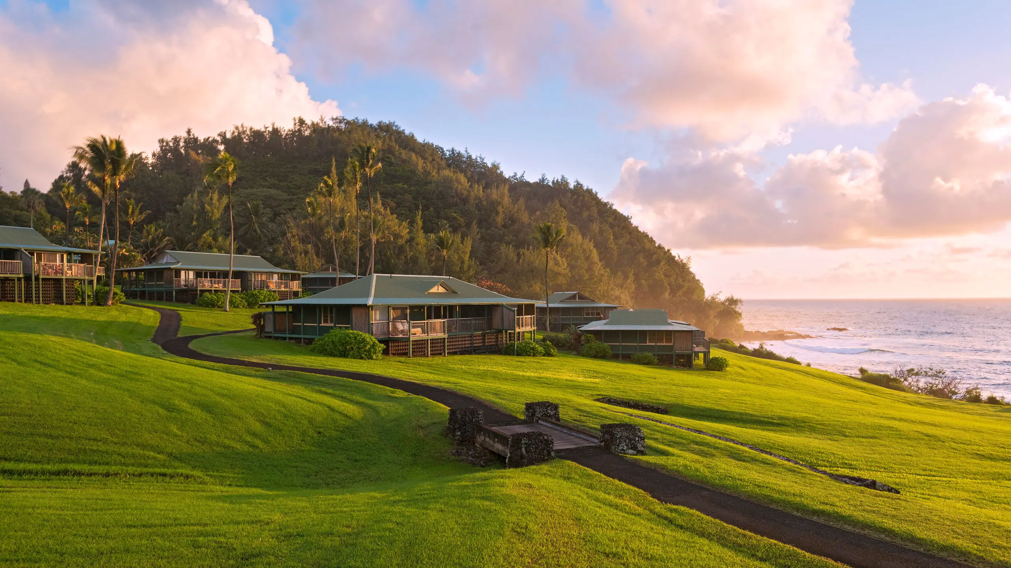 Resort In Hana Overlooking the ocean with lots of green grass and partly cloudy skies