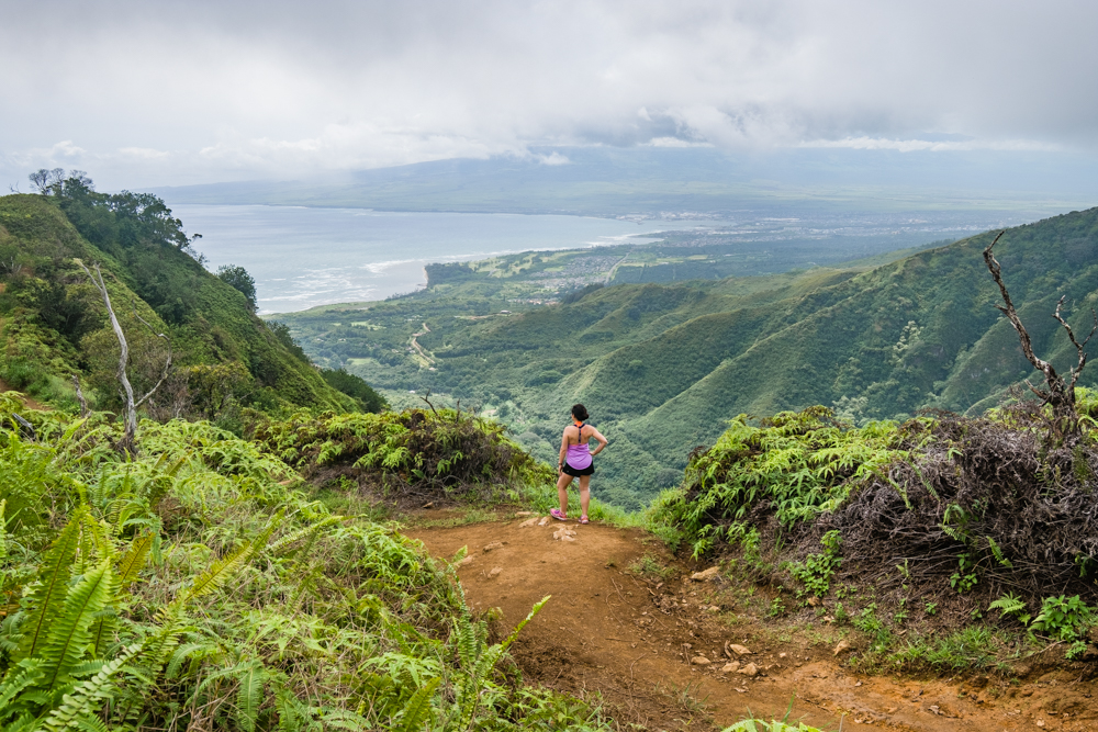 Woman walking a dirt trail on Waihee Ridge Trail in Maui