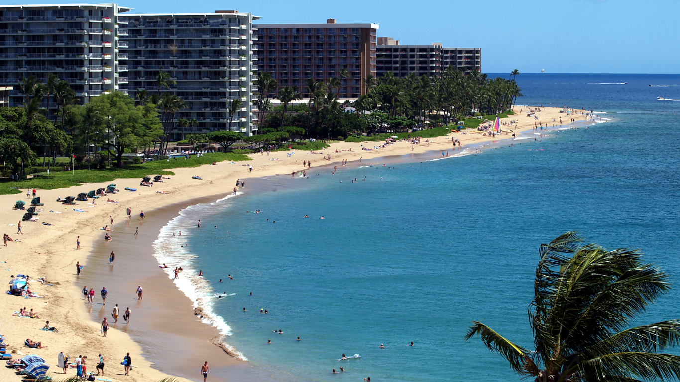 beach goers on Kaanapali Beach in Maui, Hawaii with resorts in the background