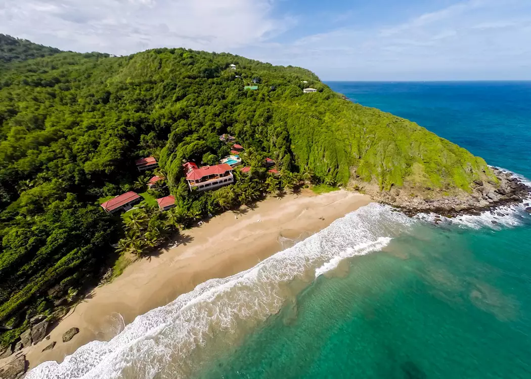 Aierel View of Petit Anse Beach in Grenada with white sand beaches, and a resort in the background