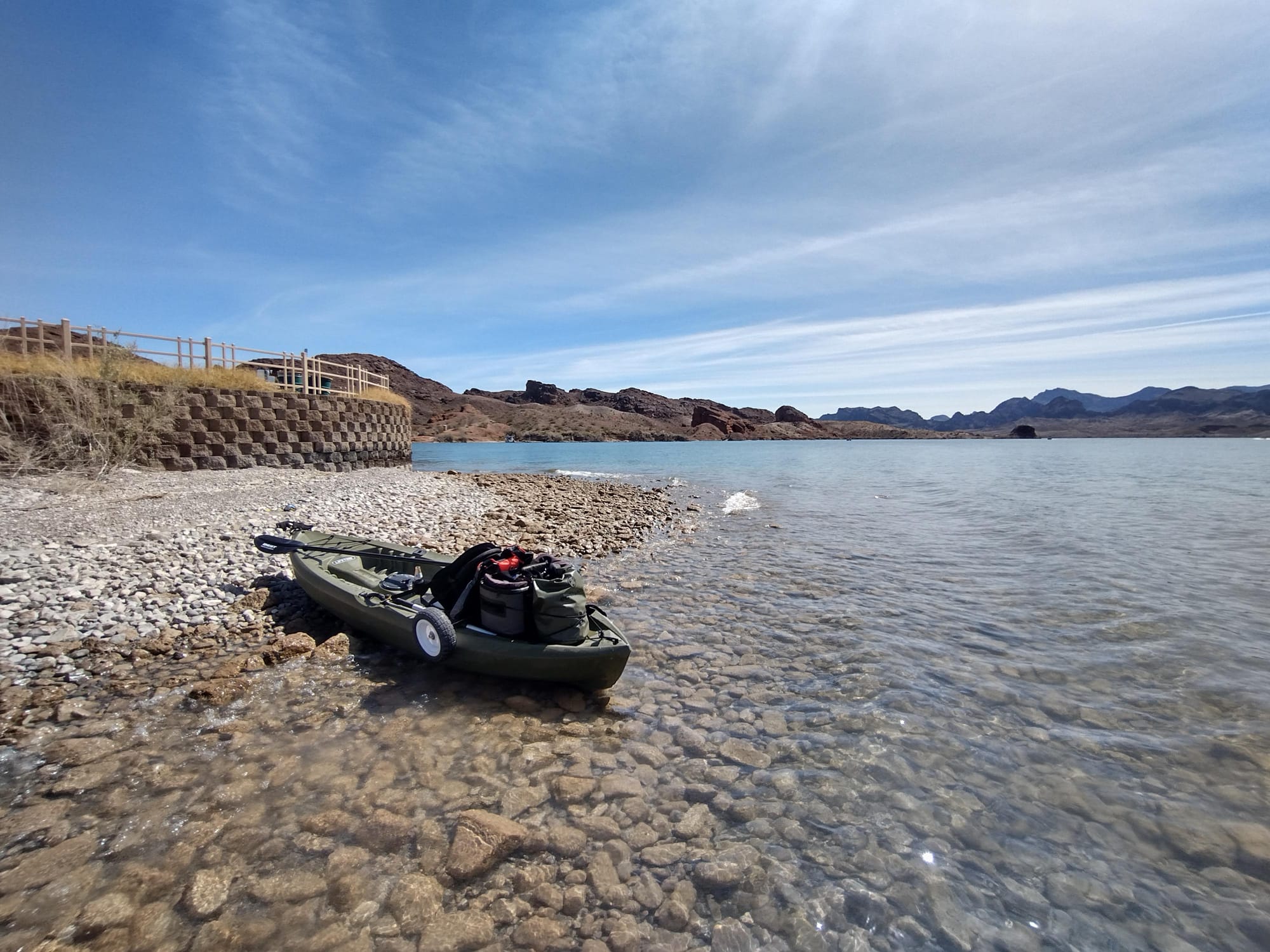 A kayak sitting on the rocks next to clear waters on Lake Havasu's Beaver Island.