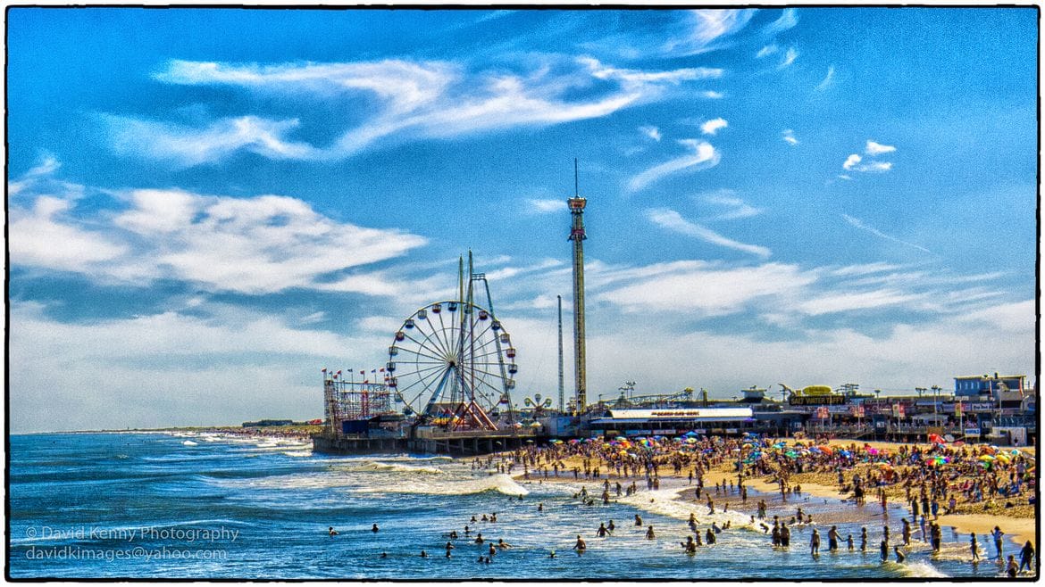 People playing the beach at Cedar Point Beach with the theme park in the background