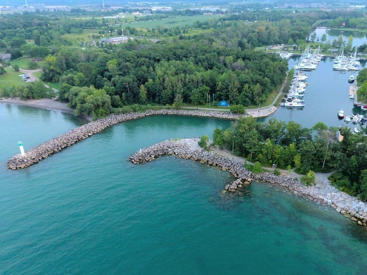 Ariel view of a marina with sailboats and other types of boats that has rocks lines as a water way for boats to come in and out of the marina at Fifty Point Conservation Area in (Grimsby, Ontario)