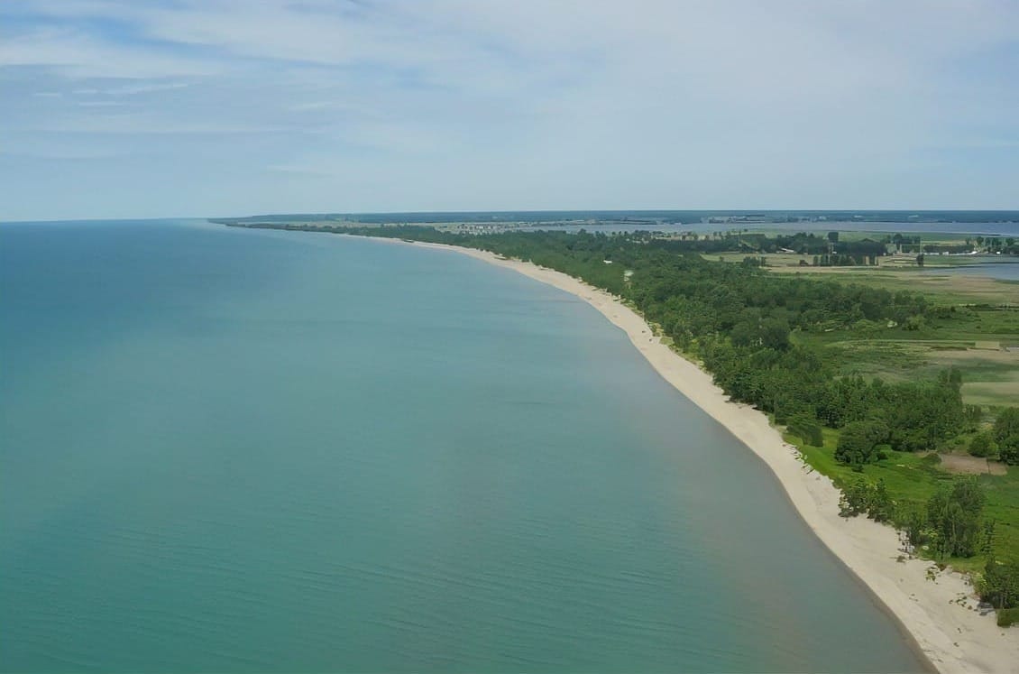 Ariel view of Long Point Beach in Ontario, Canada showing clear lake waters and white sandy beaches that stretch a few miles. 