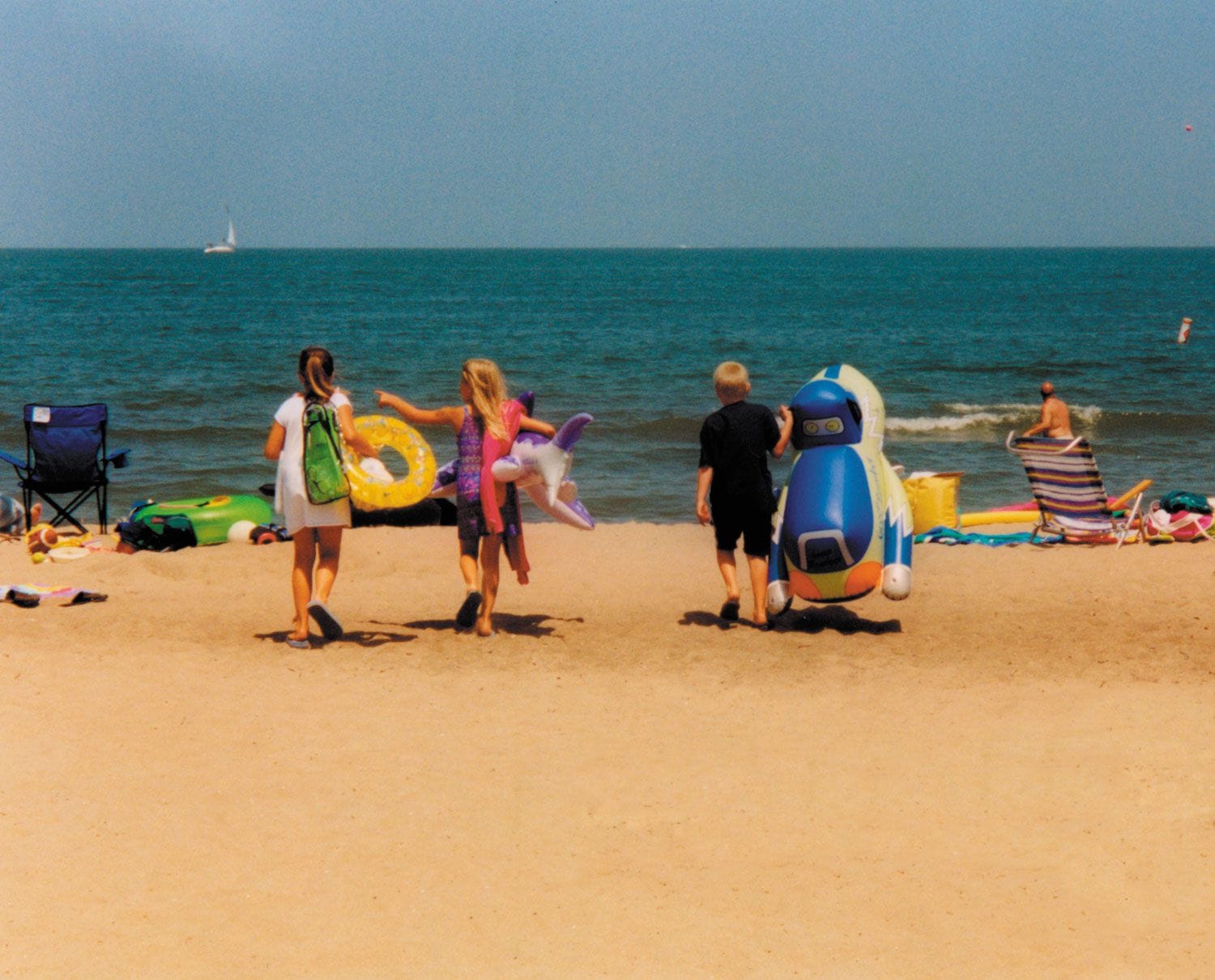 Kids carrying float toys on Nickel Plate Beach in Huron, Ohio on Lake Erie.