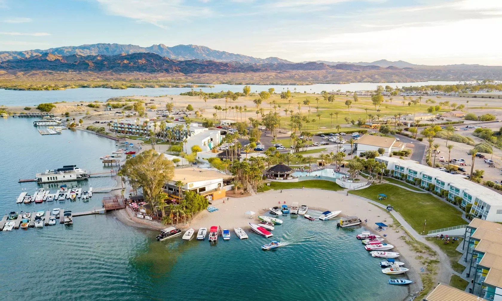 Ariel view of Rotary Community Park Beach with a sandy beach and boats parked in front of a resort. 