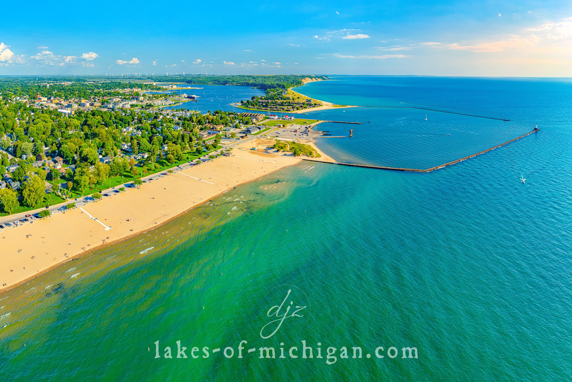 Ariel view of Ludington State Park Beach with white sandy beaches, and a protected swim area. 