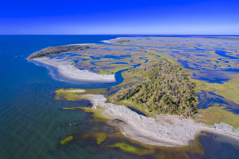 Ariel view of one of the many beaches at  Presque Isle State Park that shows that it looks like a marsh of waterways intersecting throughout the land and several beaches formed on the lakes edge. 