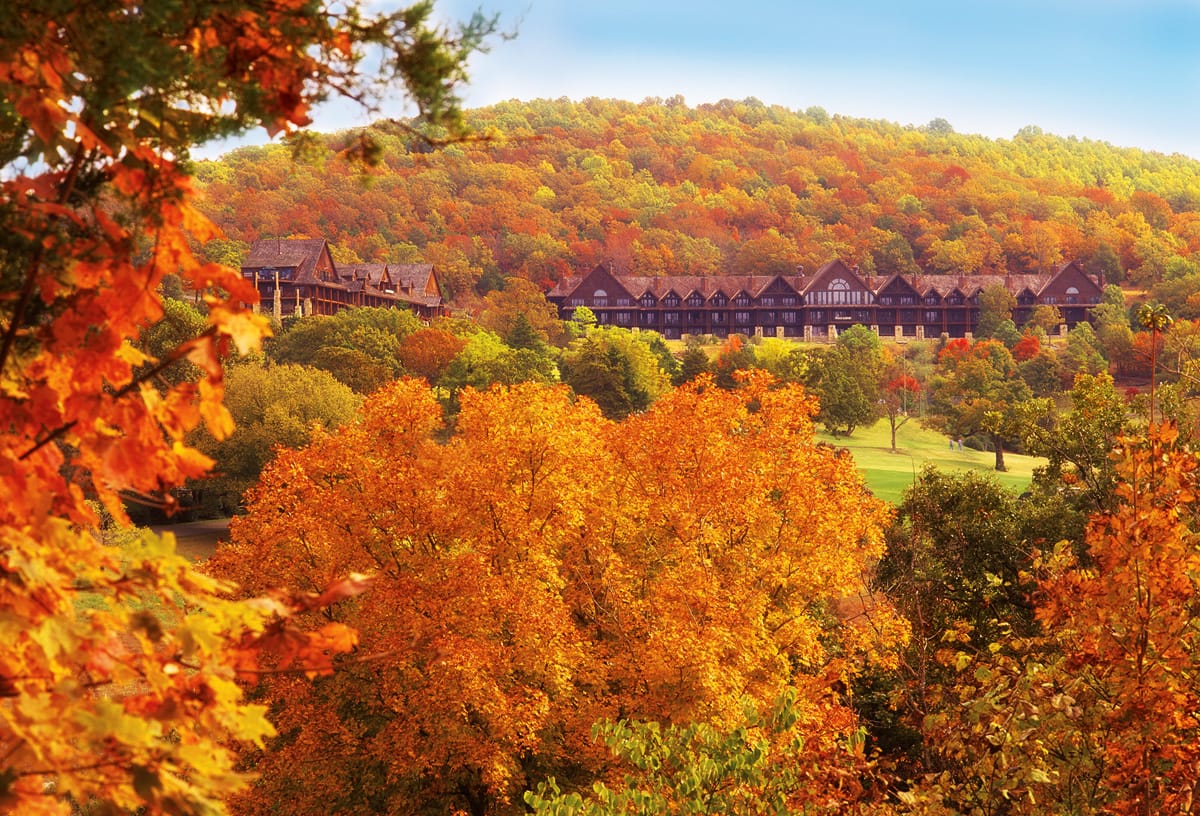 Fall leaves showing their bright colors with a resort cottage sitting down in a valley in Branson Missouri. 