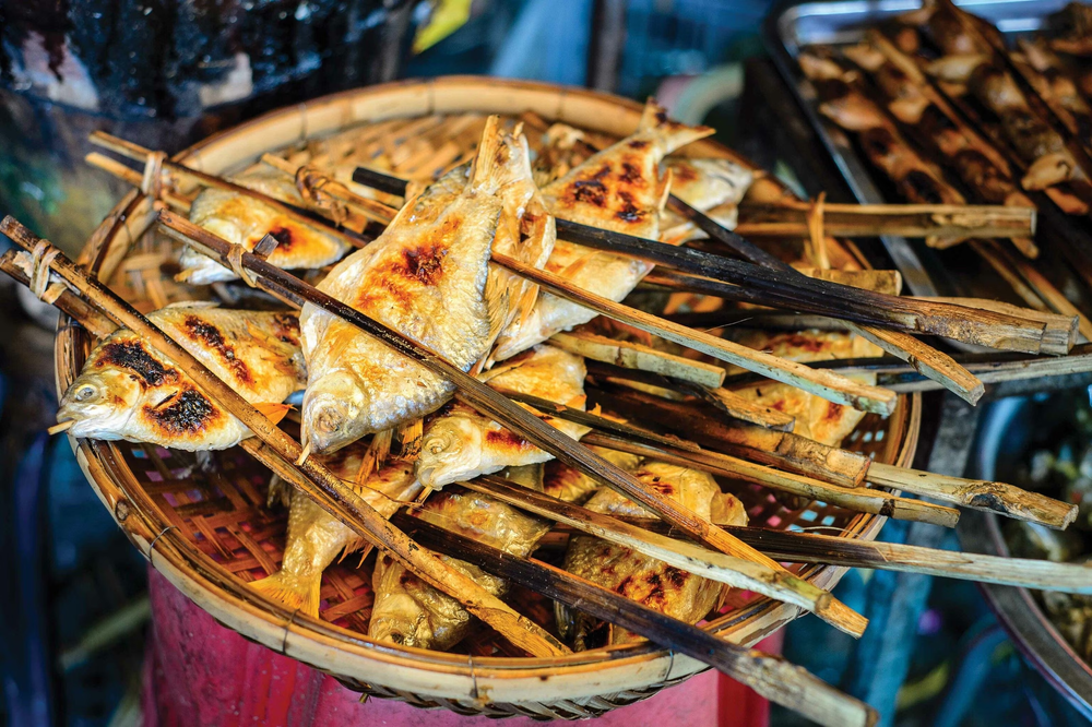 Fish on a stick that has been grilled and is now being displayed for sale to passerby's. 