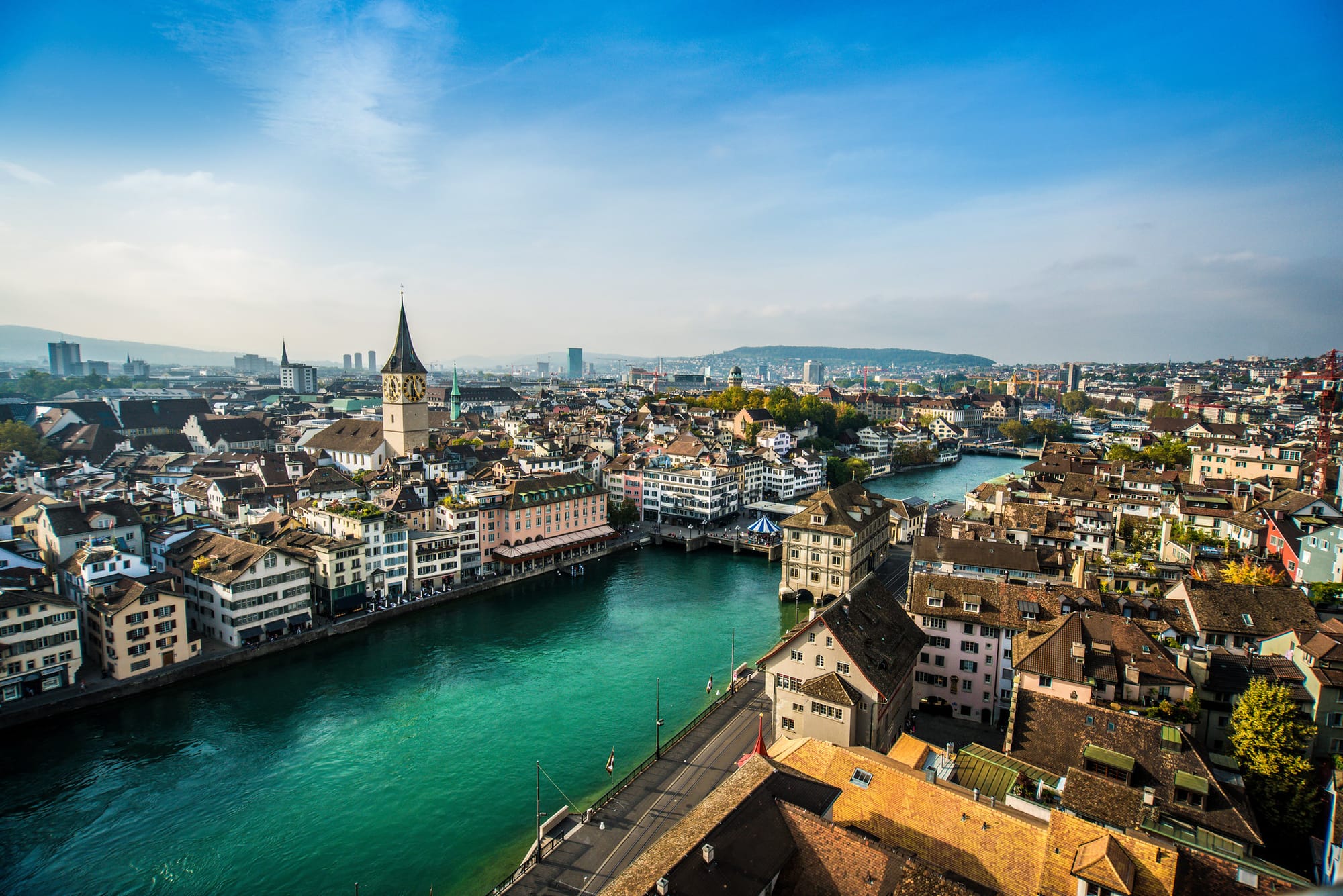 Aerial view of Zurich, Switzerland, featuring the Limmat River, historic buildings, and the iconic St. Peter's Church.