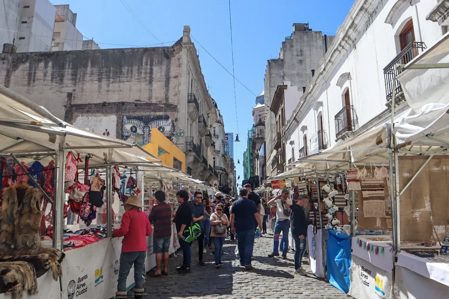 people shopping from vendors set up along the street at the San Telmo Market in Bueno Aires, Argentina 