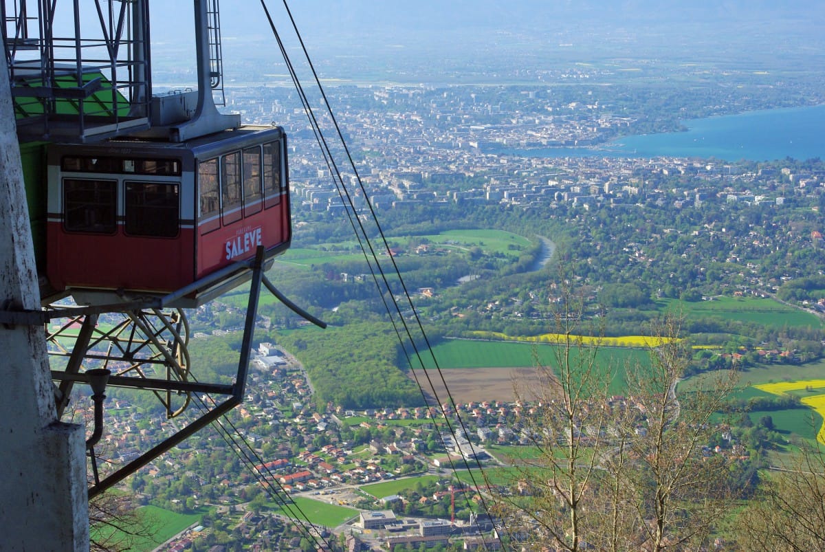 A red cable car at the top of Mont Salève over looking Geneva down below. 