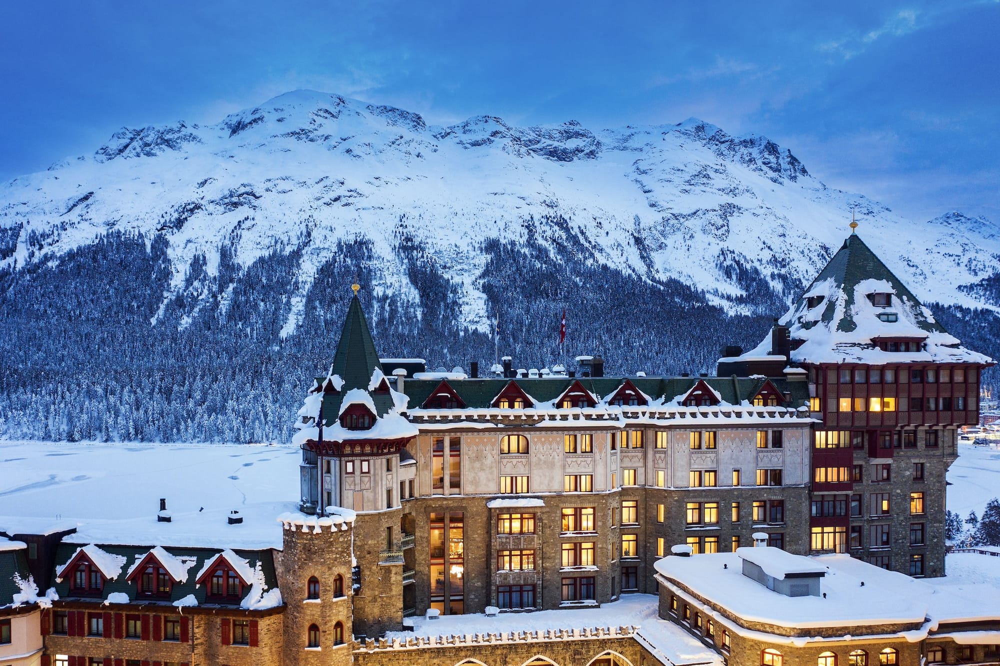 Badrutt’s Palace Hotel in St. Moritz, Switzerland, a grand alpine resort with snow-covered rooftops and mountain views.