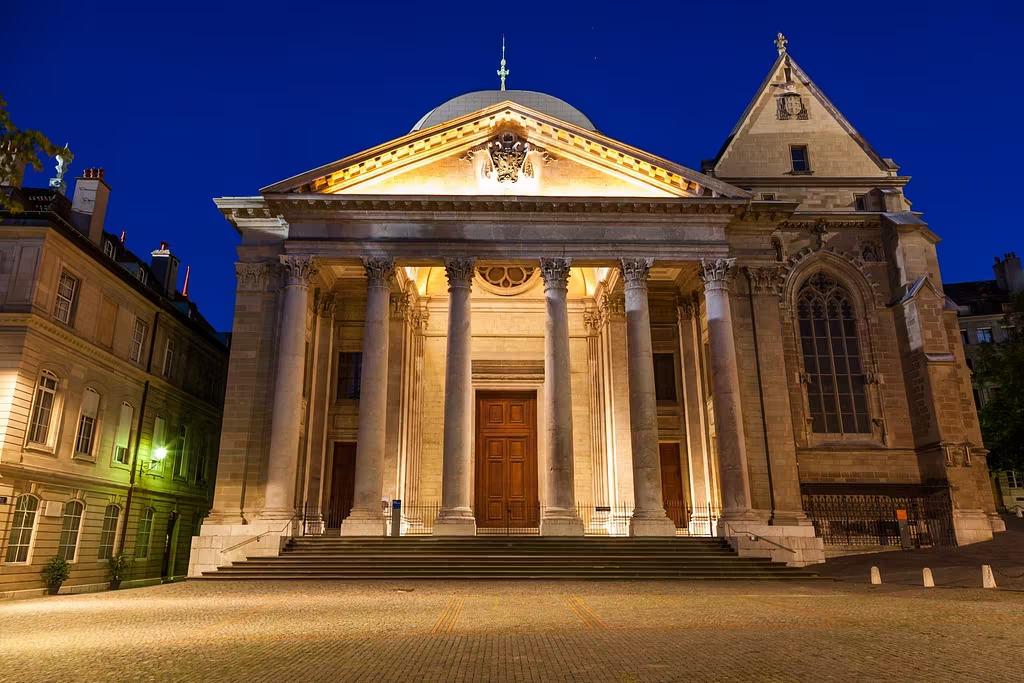 St. Pierre Cathedral in Geneva is a la 6 column museum that has a roman aesthetic to it lit up at night.