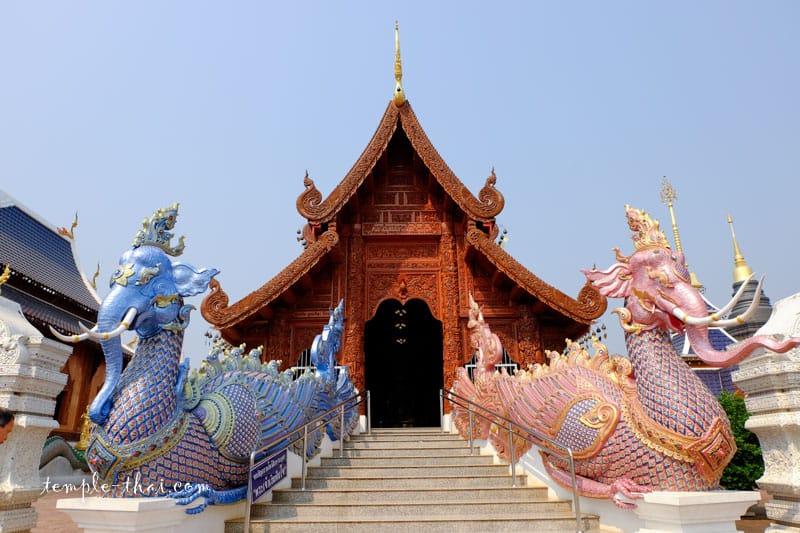 Temple with the entrance to the stairs having a blue dragon leading up the left hand side of the stairs and a pink dragon on the right hand side.  