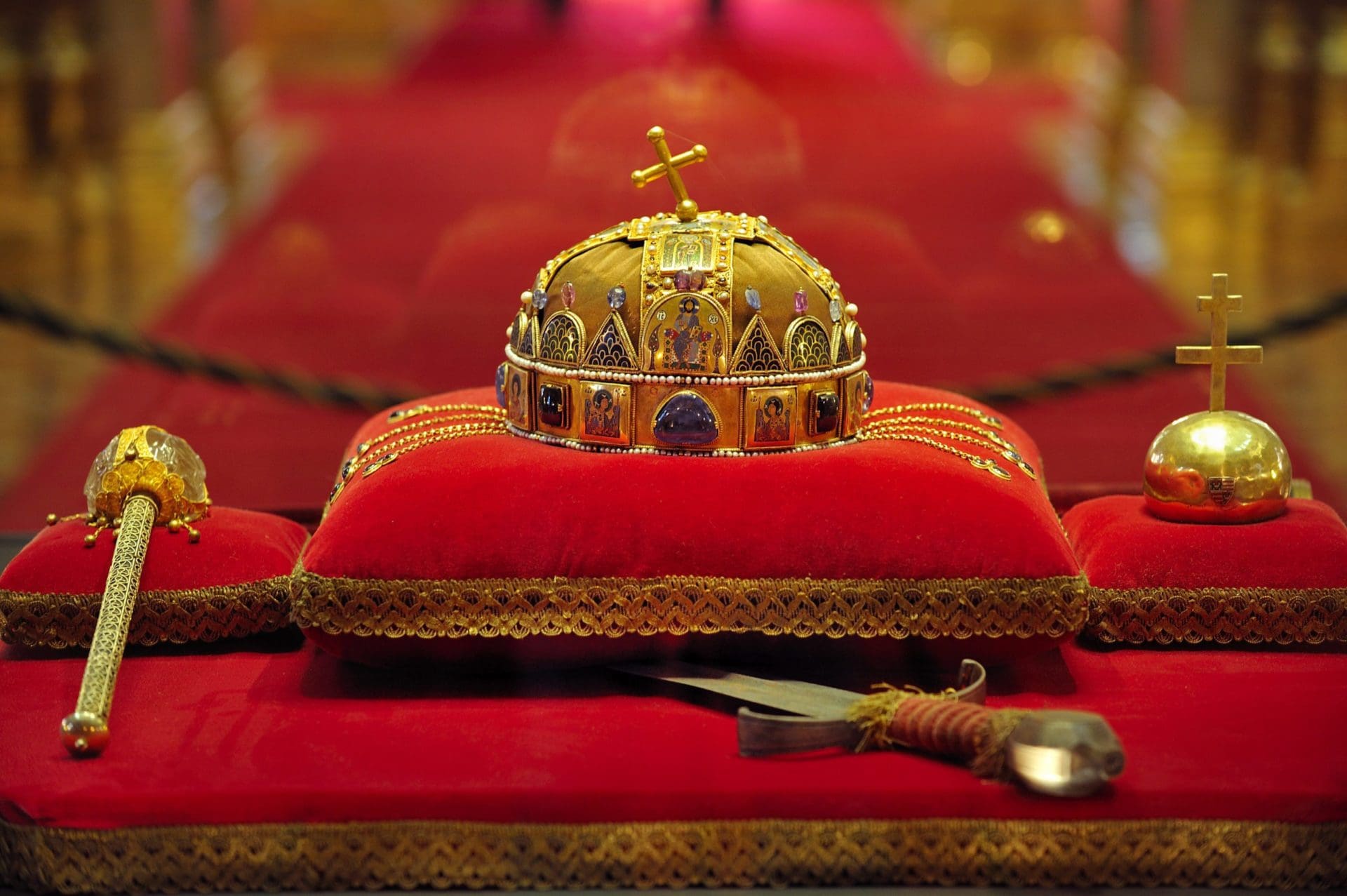 The crown of St. Stephen on display sitting on a red pillow behind a glass case inside Budapest Parliament Building. 