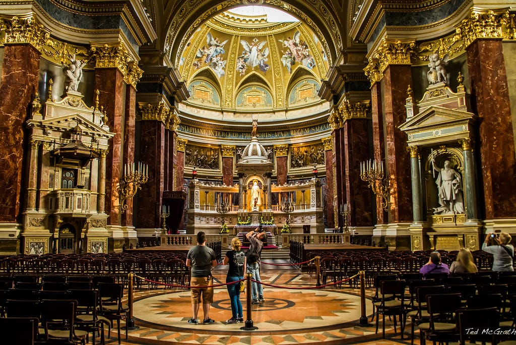 People looking at the beauty of the inside of St. Stephen’s Basilica in Budapest.