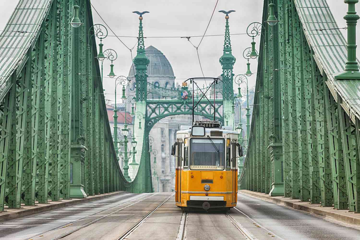 Yellow vintage tram in Budapest crossing a bridge. 