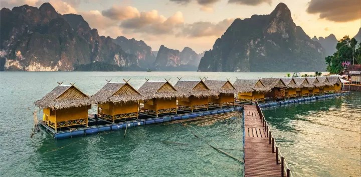 Khao Sok National Park floating resort huts on a lake with mountains in the background.