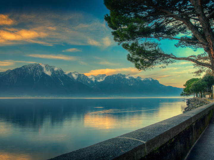 Views of snow capped mountain peaks at the edge of lake Geneva, Switzerland.