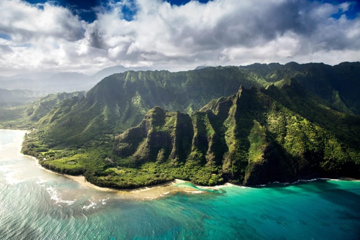 Ariel view of the ocean and jagged mountains in Kauai, Hawaii