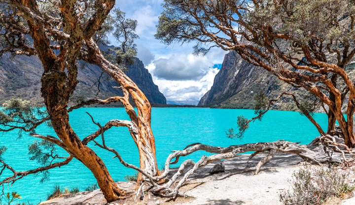 A Beautiful blue pristine looking lake lay between two large barren mountains at Huascarán National Park