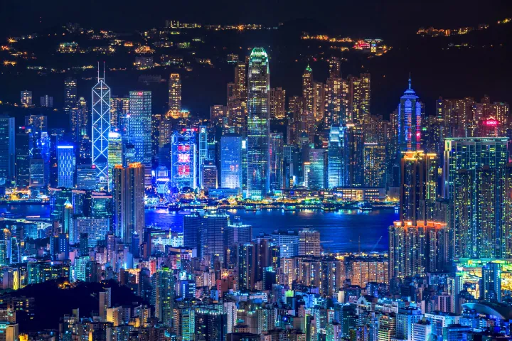 Hong Kong's impressive waterfront Skyline lit up with bright lights at night.